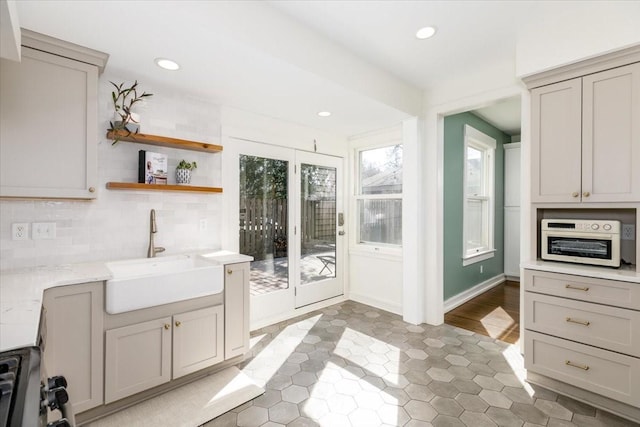 kitchen with a sink, range with gas cooktop, decorative backsplash, and recessed lighting