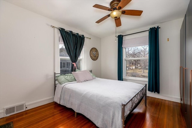 bedroom with visible vents, baseboards, and wood finished floors