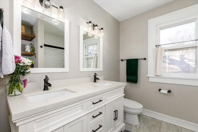 full bath with double vanity, toilet, baseboards, and a sink