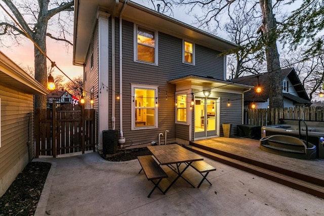 rear view of property with a gate, a wooden deck, and fence