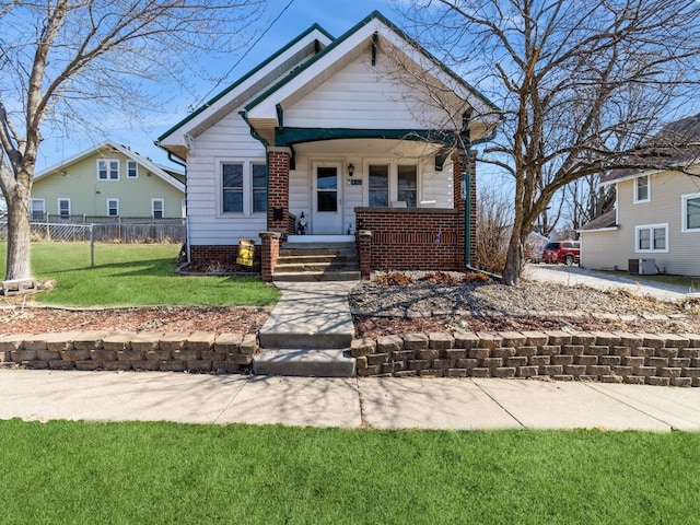 view of front of home featuring central air condition unit, a porch, a front yard, and fence