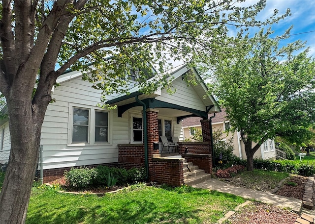 410 1st St S, Newton, IA 50208 - bungalow-style house with covered porch and a front yard