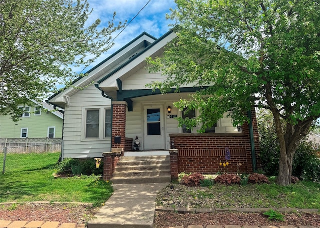 410 1st St S, Newton, IA 50208 - bungalow featuring brick siding, fence, and a front yard
