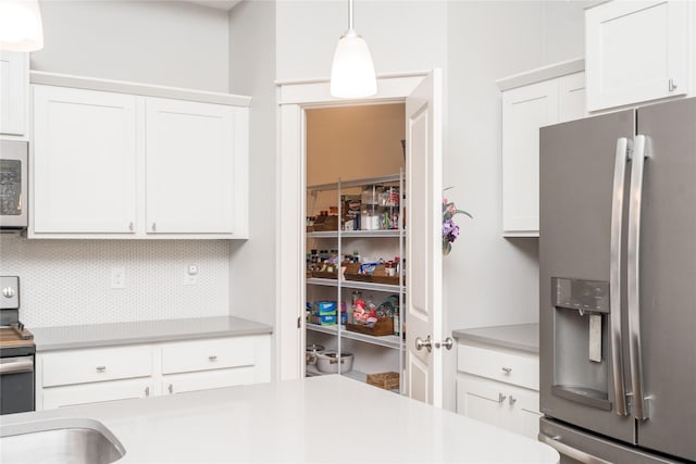 kitchen with white cabinetry, stainless steel appliances, and light countertops