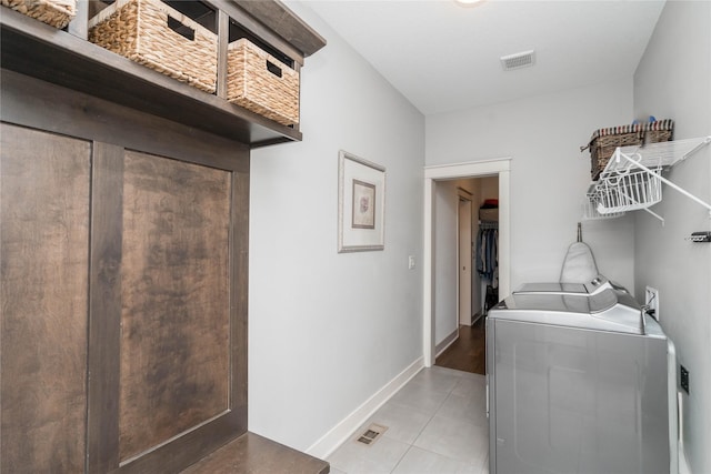 clothes washing area featuring visible vents, baseboards, laundry area, light tile patterned flooring, and separate washer and dryer