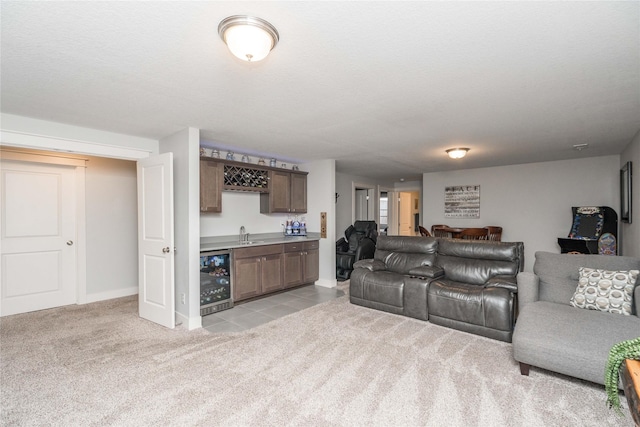 living room with wet bar, a textured ceiling, beverage cooler, and light carpet