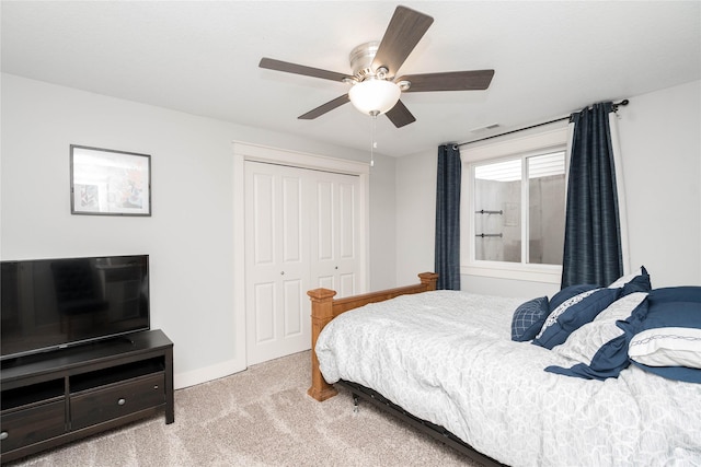 carpeted bedroom featuring a closet, visible vents, baseboards, and ceiling fan