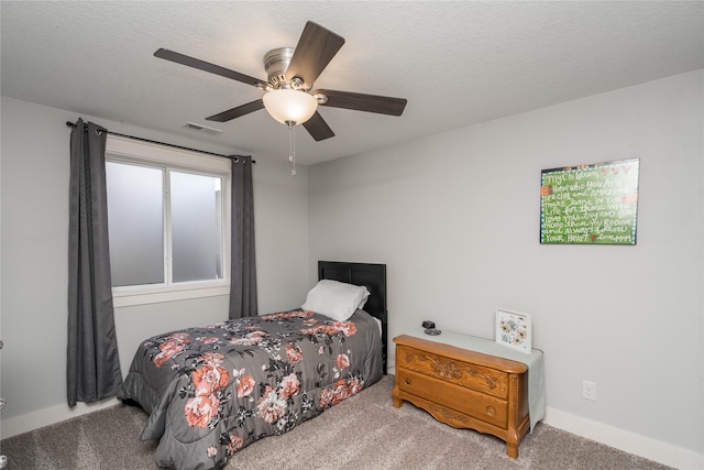 bedroom featuring ceiling fan, visible vents, carpet floors, and a textured ceiling