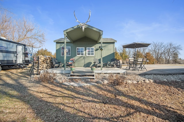 rear view of property with an outbuilding and a deck