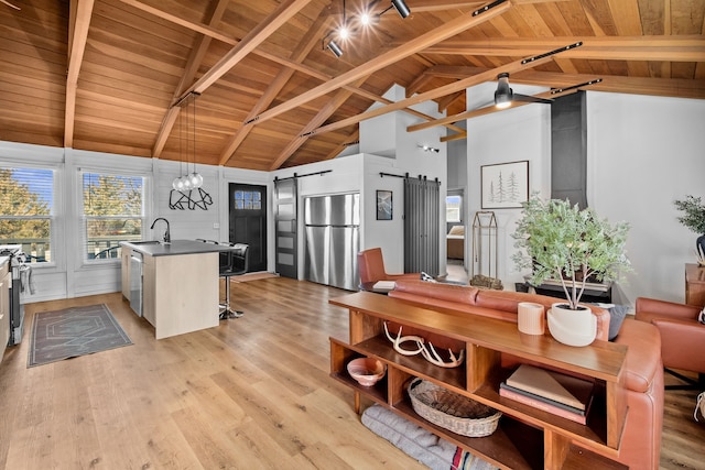 kitchen featuring light wood-type flooring, a barn door, wooden ceiling, and stainless steel appliances