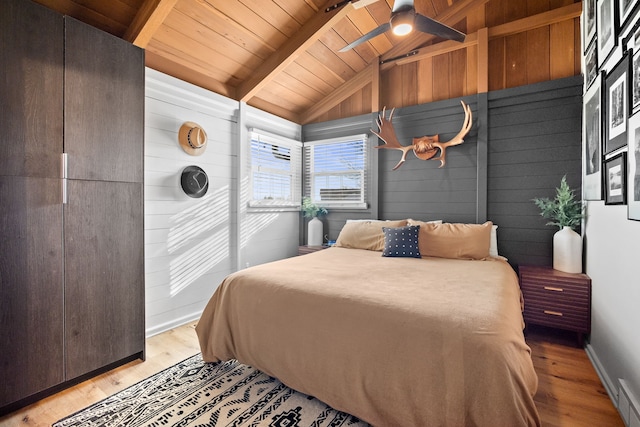 bedroom with light wood-type flooring, wood walls, baseboards, wood ceiling, and vaulted ceiling with beams