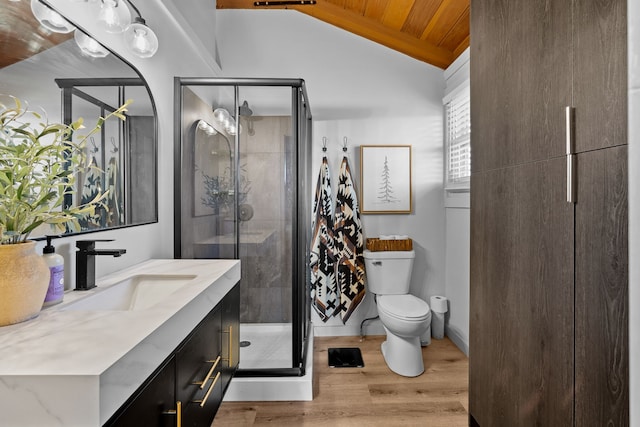 bathroom featuring vanity, wood finished floors, lofted ceiling, a shower stall, and toilet