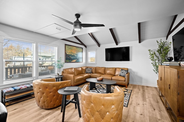 living area featuring baseboards, ceiling fan, vaulted ceiling with beams, and light wood finished floors