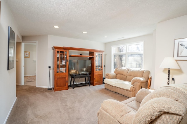 living room featuring recessed lighting, a textured ceiling, baseboards, and carpet