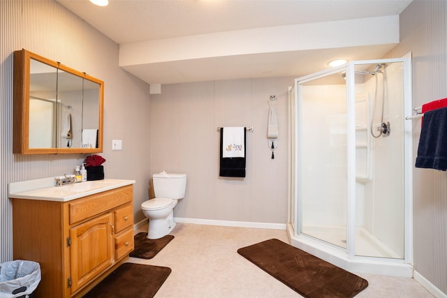 bathroom with baseboards, a shower stall, vanity, and toilet