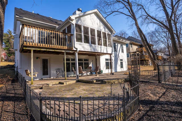 rear view of property with a patio, fence private yard, a chimney, and a sunroom