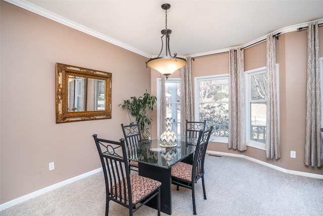 dining space featuring carpet flooring, baseboards, and ornamental molding