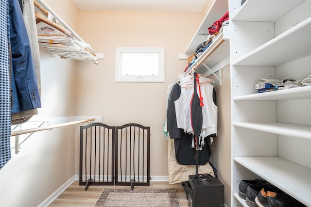 walk in closet with wood finished floors