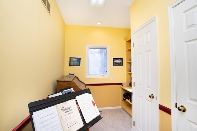 interior space featuring visible vents, baseboards, and carpet