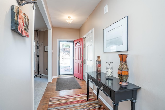 foyer with baseboards and wood finished floors