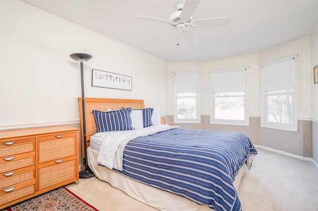 bedroom featuring a ceiling fan, multiple windows, carpet, and baseboards