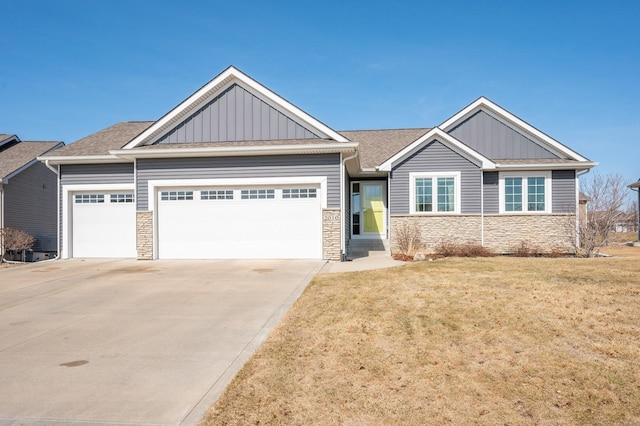 craftsman house featuring a garage, stone siding, and board and batten siding