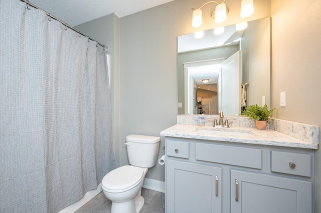 bathroom with vanity, toilet, baseboards, and tile patterned flooring