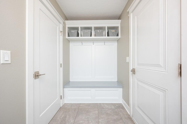 mudroom with a textured ceiling and light tile patterned flooring