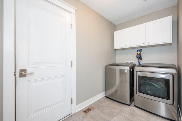 laundry room featuring visible vents, baseboards, light tile patterned floors, cabinet space, and independent washer and dryer