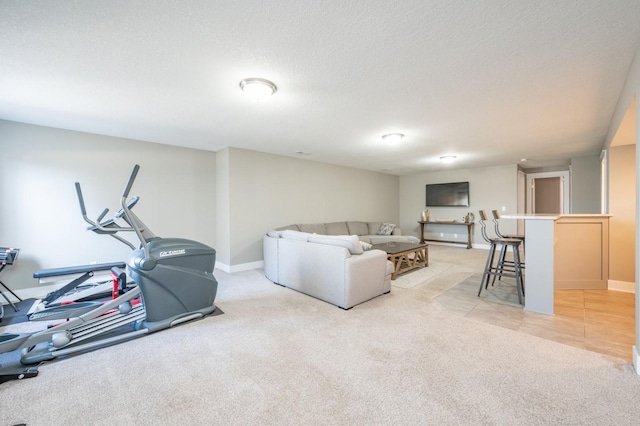 living room featuring light colored carpet, a textured ceiling, and baseboards