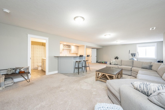 living area featuring light carpet, visible vents, a textured ceiling, and bar area