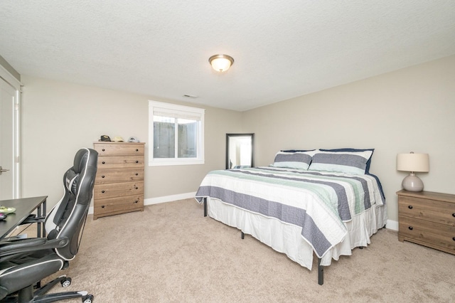 bedroom with baseboards, light carpet, and a textured ceiling