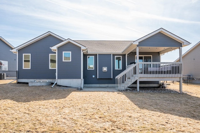 view of front of property with fence, central AC, and roof with shingles