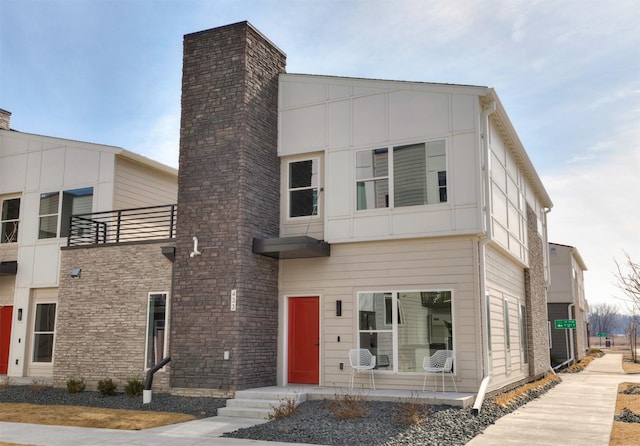 modern home featuring a balcony and a chimney