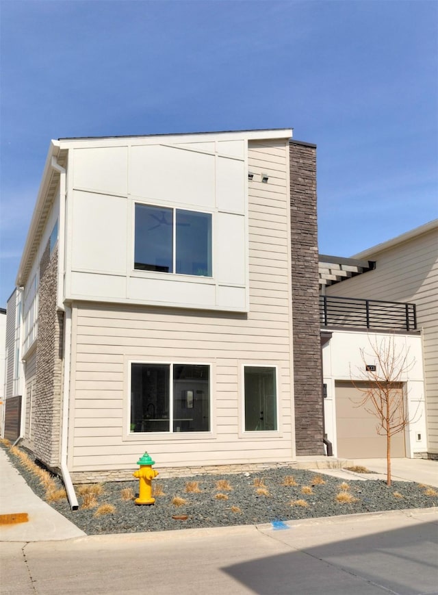 exterior space featuring an attached garage, driveway, and a chimney