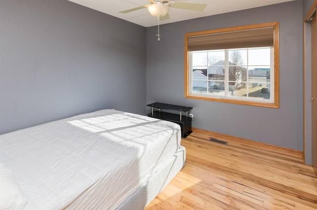 bedroom with visible vents, wood finished floors, and a ceiling fan