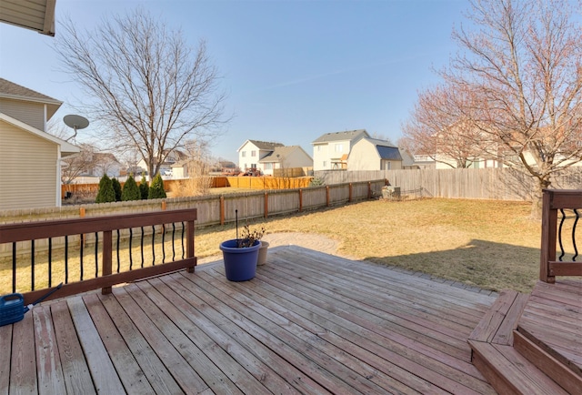 wooden terrace with a residential view, a lawn, and a fenced backyard