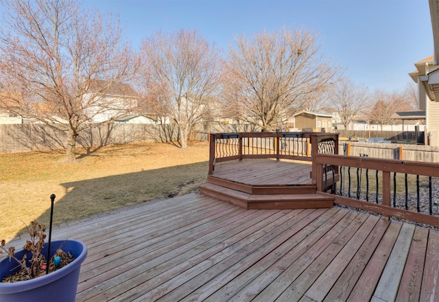 wooden deck featuring a residential view, a lawn, and a fenced backyard