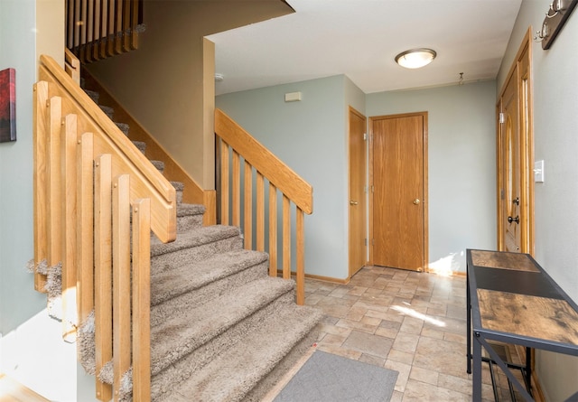 stairway featuring stone finish flooring and baseboards