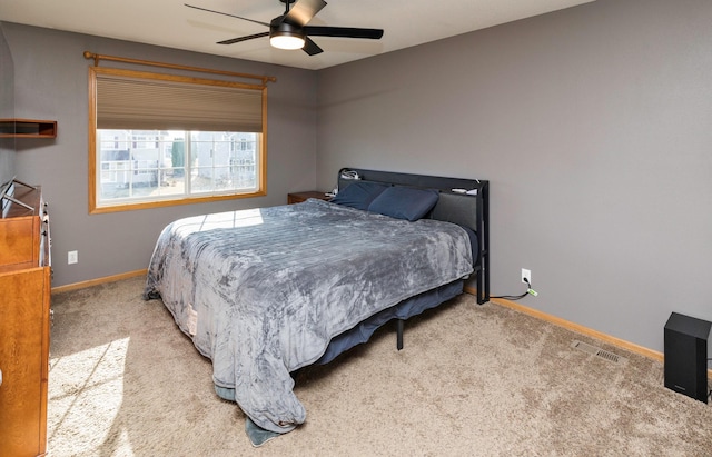 carpeted bedroom featuring visible vents, baseboards, and a ceiling fan