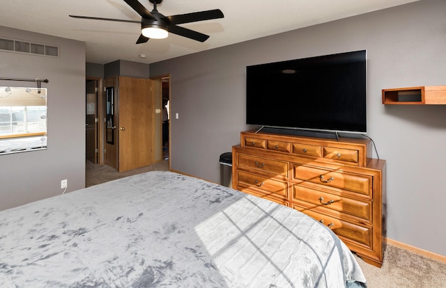 carpeted bedroom with visible vents, baseboards, and ceiling fan