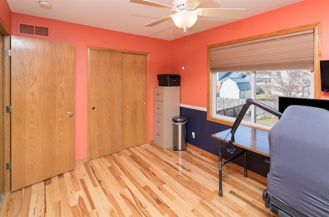 office area with ceiling fan, visible vents, and wood finished floors