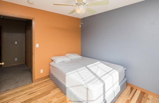 bedroom with baseboards, light wood-style floors, and a ceiling fan