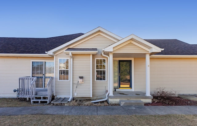 entrance to property with a shingled roof