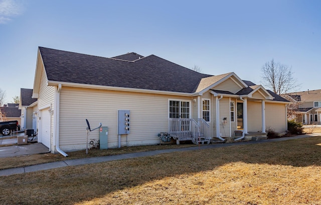 ranch-style house featuring a garage, roof with shingles, and a front yard