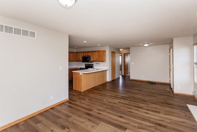 kitchen with visible vents, stainless steel microwave, open floor plan, light countertops, and electric range