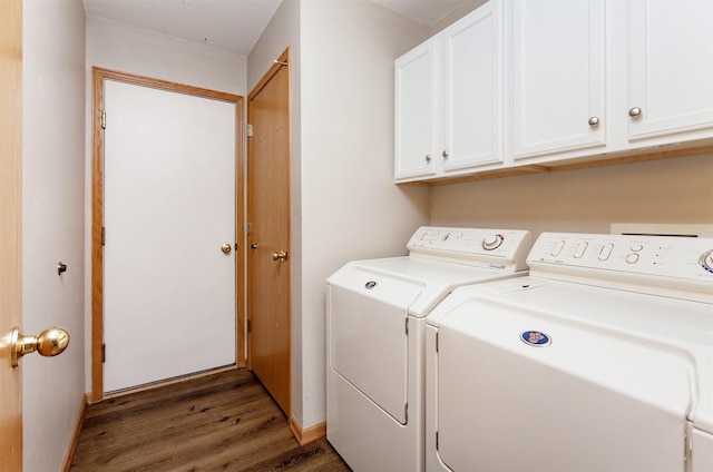 clothes washing area with washer and clothes dryer, cabinet space, and wood finished floors