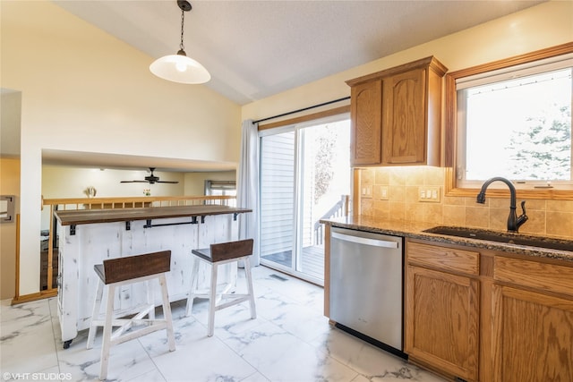 kitchen featuring a sink, lofted ceiling, stainless steel dishwasher, and marble finish floor