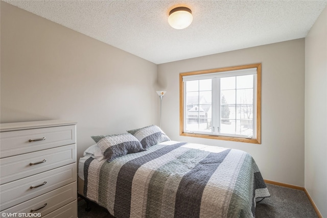 carpeted bedroom with baseboards and a textured ceiling