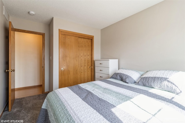 bedroom with baseboards, carpet, a closet, and a textured ceiling